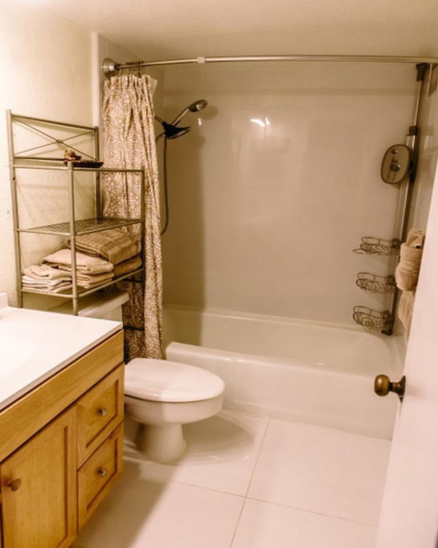 full bathroom featuring vanity, shower / tub combo, tile patterned floors, and toilet