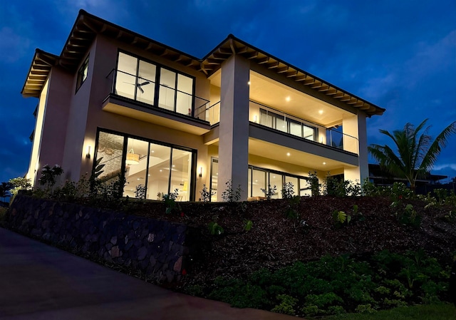 property exterior at twilight featuring a balcony