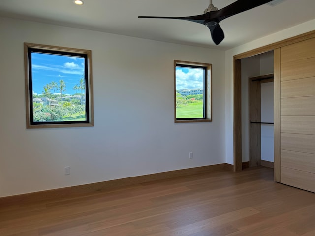 unfurnished bedroom featuring ceiling fan, a closet, and light hardwood / wood-style flooring