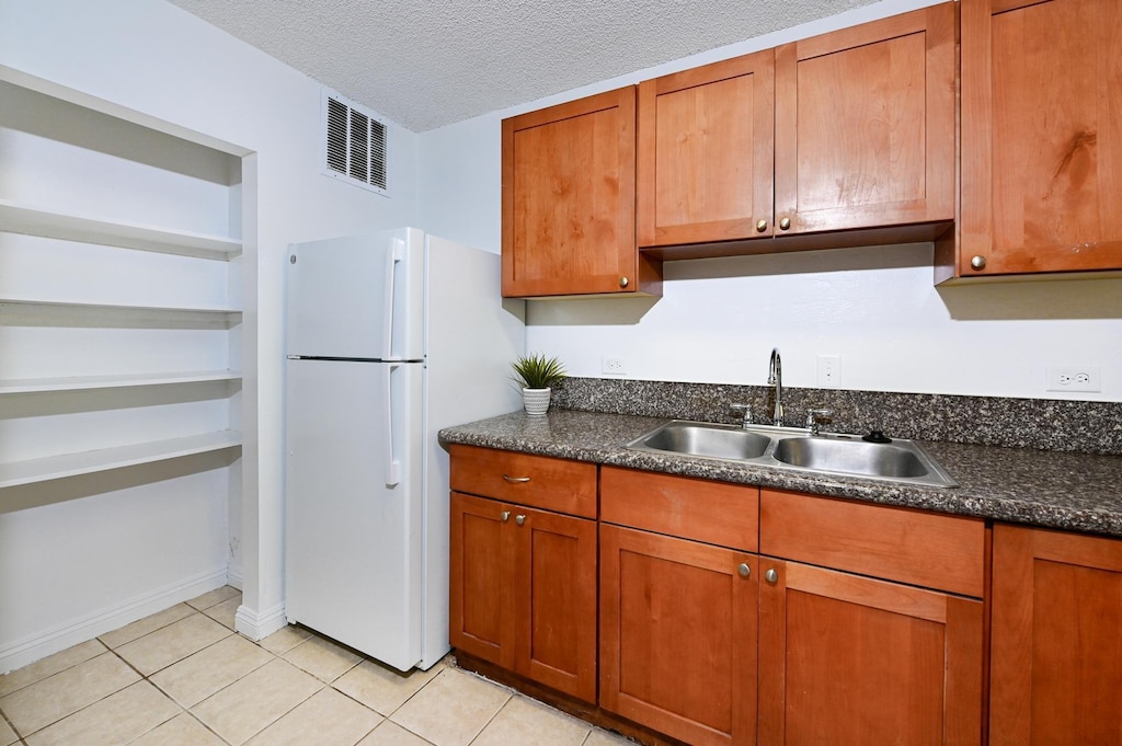 kitchen featuring white electric range, stone countertops, light tile patterned flooring, and sink