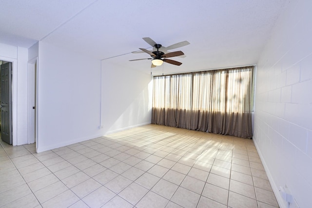 tiled spare room featuring ceiling fan