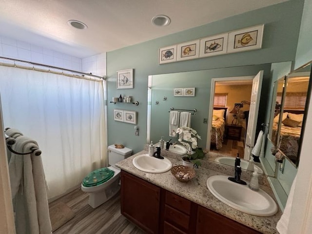 bathroom featuring walk in shower, hardwood / wood-style floors, vanity, and toilet