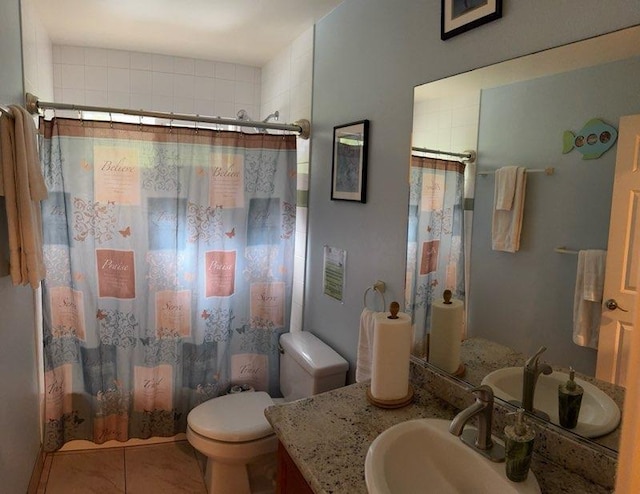 full bathroom featuring tile patterned flooring, vanity, toilet, and shower / bath combo with shower curtain