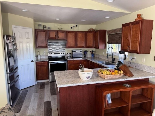 kitchen with kitchen peninsula, light stone countertops, dark hardwood / wood-style flooring, stainless steel appliances, and sink