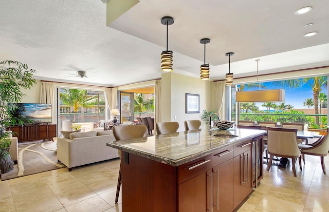 130 Kai Malina Pkwy Unit Nr202, Lahaina, HI 96761 - kitchen featuring a sink, light tile patterned floors, a kitchen island, ceiling fan, and hanging light fixtures