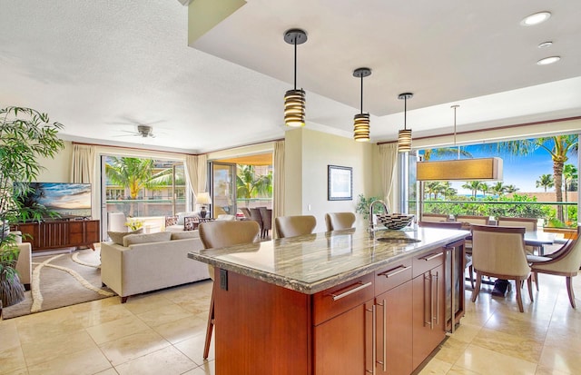 130 Kai Malina Pkwy Unit Nr202, Lahaina, HI 96761 - kitchen featuring a kitchen island, a sink, a ceiling fan, hanging light fixtures, and light tile patterned floors