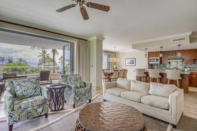 130 Kai Malina Pkwy Unit Nr202, Lahaina, HI 96761 - living area with ceiling fan, a textured ceiling, and crown molding