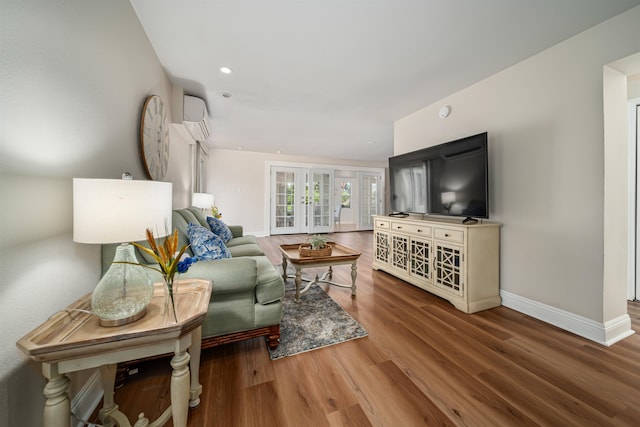 living room with a wall unit AC, french doors, and wood-type flooring