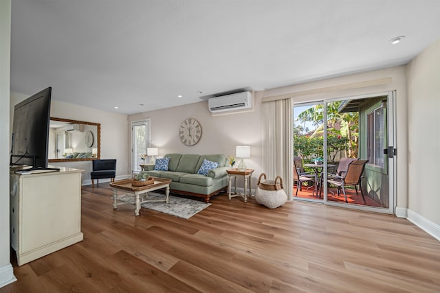 living room featuring a healthy amount of sunlight, a wall mounted AC, and wood-type flooring