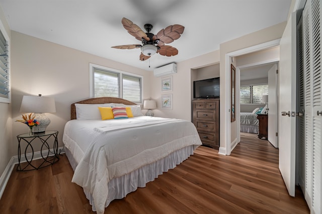 bedroom with dark hardwood / wood-style flooring, a closet, ceiling fan, and a wall mounted air conditioner