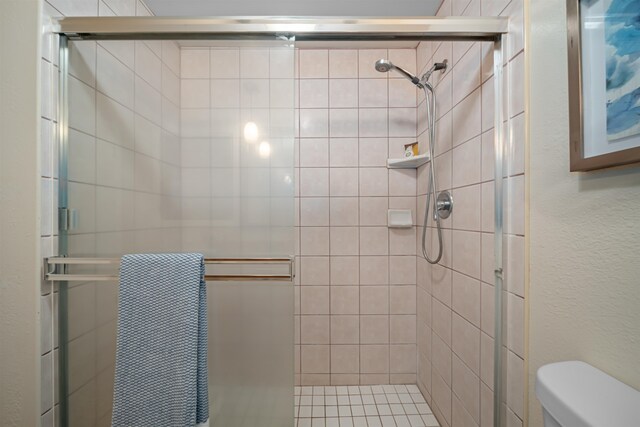 bathroom with an enclosed shower and toilet