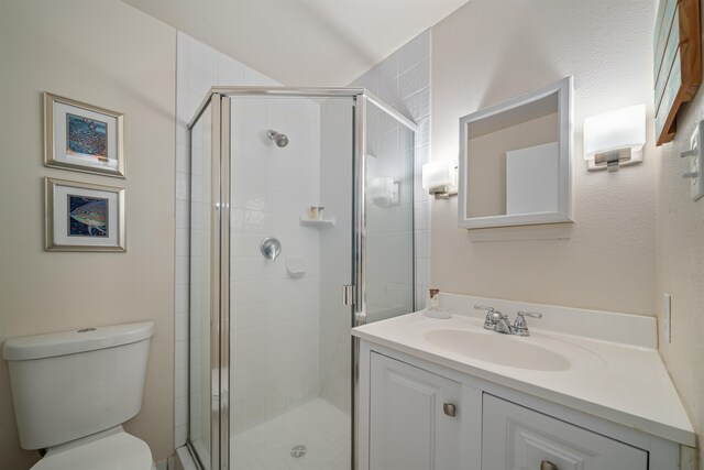 bathroom with an enclosed shower, vanity, and toilet