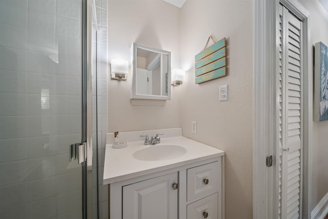 bathroom featuring a shower with shower door and vanity with extensive cabinet space