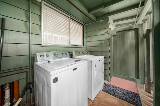 washroom with wooden walls and washing machine and dryer