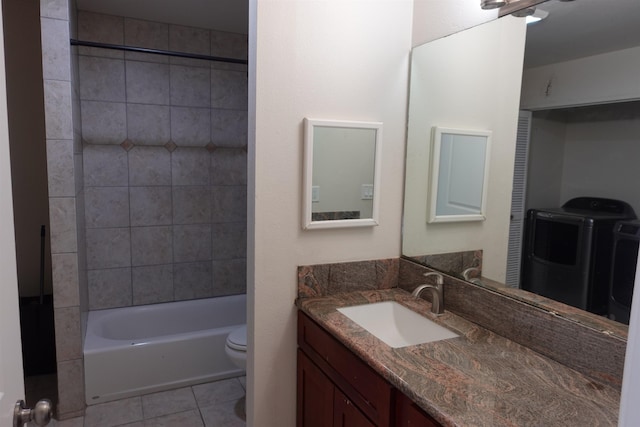 full bathroom with tiled shower / bath, washer / clothes dryer, vanity, toilet, and tile patterned floors