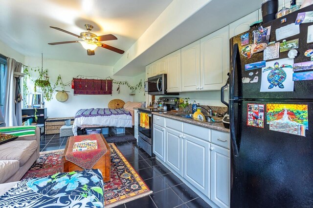 kitchen with dark tile patterned floors, white cabinetry, appliances with stainless steel finishes, and sink