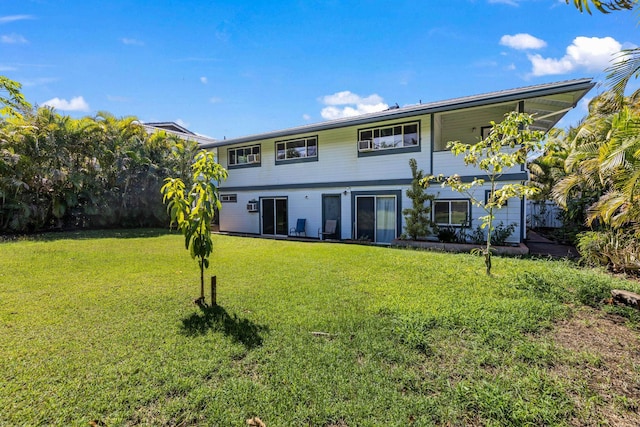 rear view of house featuring a lawn