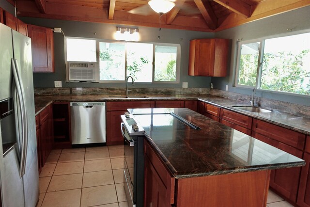 kitchen with sink, light tile patterned floors, a kitchen island, and appliances with stainless steel finishes