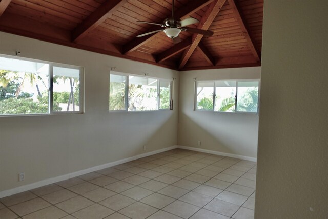 spare room with vaulted ceiling with beams, a healthy amount of sunlight, light tile patterned floors, and ceiling fan