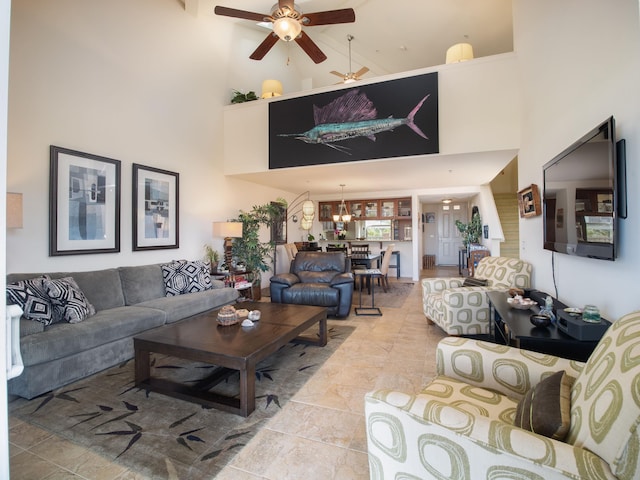 living room featuring ceiling fan with notable chandelier and a towering ceiling