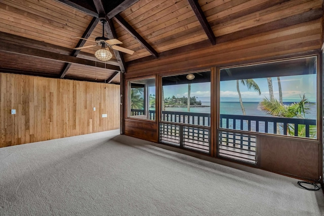 unfurnished sunroom featuring lofted ceiling with beams, ceiling fan, a water view, and wooden ceiling