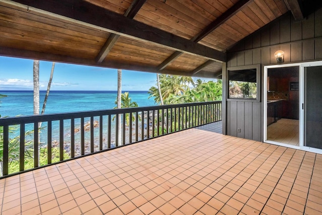 exterior space with a balcony, a water view, and a beach view