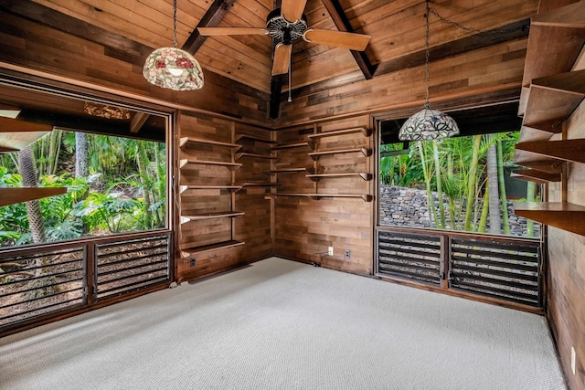 unfurnished room featuring wooden walls, carpet floors, wooden ceiling, and ceiling fan