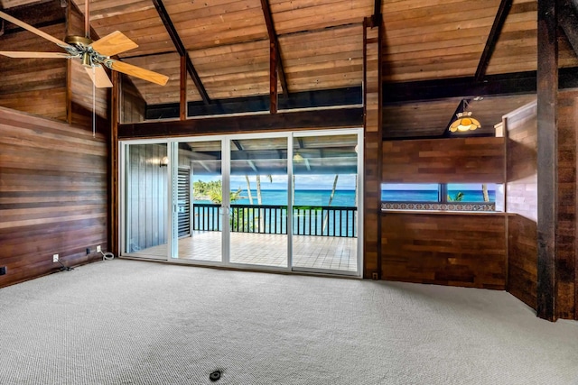 carpeted empty room with vaulted ceiling with beams, ceiling fan, wood walls, and wood ceiling