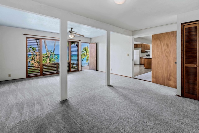 basement with ceiling fan, carpet floors, and white refrigerator