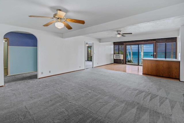 carpeted empty room featuring ceiling fan, cooling unit, and a water view