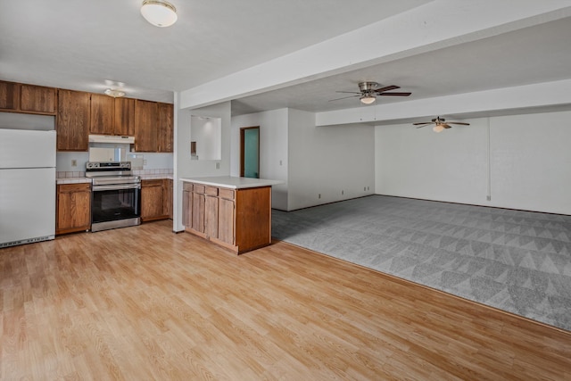 kitchen featuring ceiling fan, kitchen peninsula, white fridge, stainless steel range with electric cooktop, and light wood-type flooring