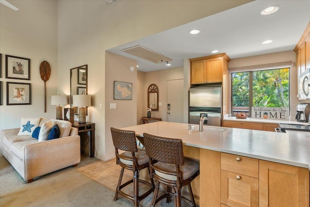 kitchen featuring stainless steel appliances, a breakfast bar, a sink, and recessed lighting