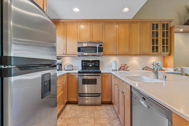 kitchen with appliances with stainless steel finishes, recessed lighting, light countertops, and a sink