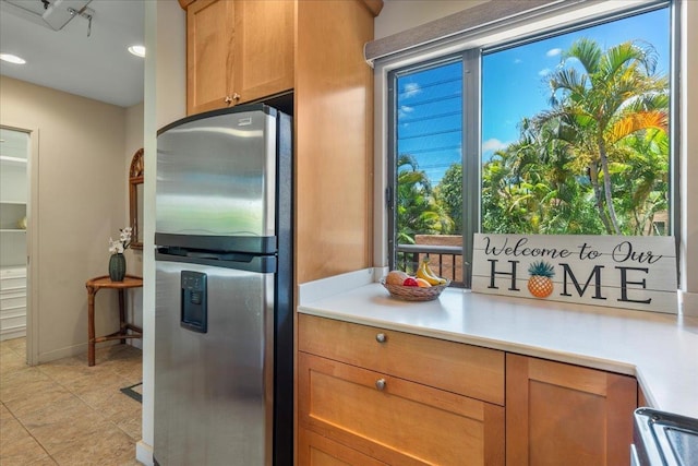 kitchen featuring range, stainless steel refrigerator with ice dispenser, and light countertops