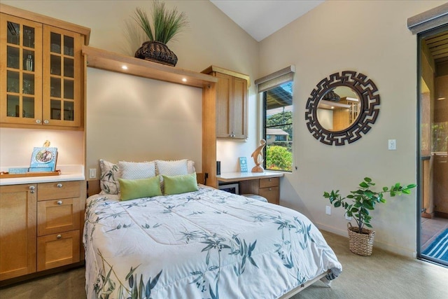 bedroom with lofted ceiling, dark carpet, and baseboards