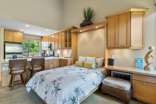 bedroom with carpet, stainless steel fridge, a high ceiling, and recessed lighting