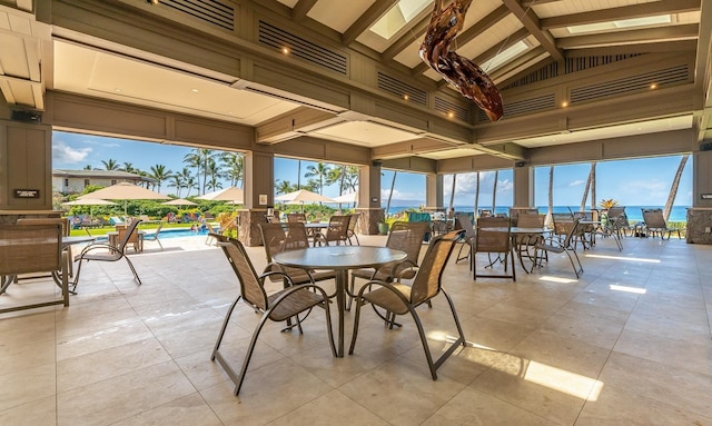 sunroom / solarium featuring lofted ceiling with beams