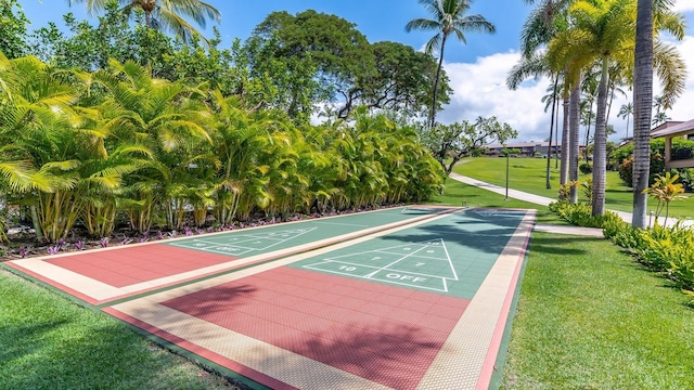 view of home's community featuring shuffleboard and a yard