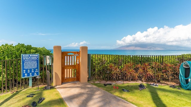 exterior space featuring a water view, fence, and a gate