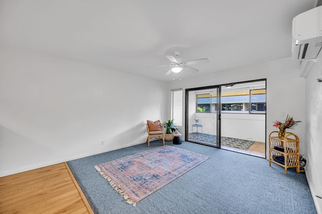 sitting room featuring wood finished floors, a ceiling fan, carpet floors, baseboards, and a wall mounted AC