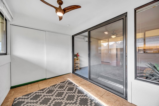 interior space with tile patterned floors, ceiling fan, and an AC wall unit