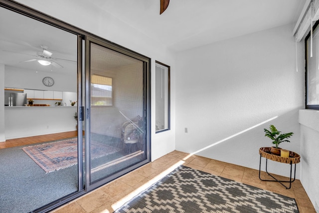 interior space with tile patterned floors and a ceiling fan