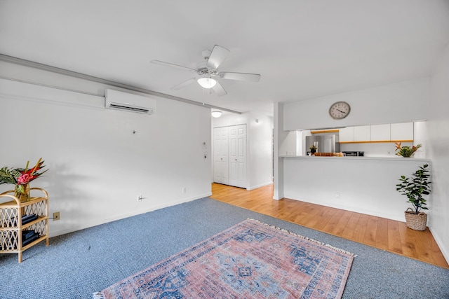 living area with ceiling fan, an AC wall unit, baseboards, and carpet