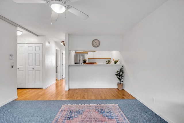 interior space featuring ceiling fan, carpet, and baseboards
