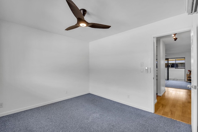 carpeted spare room with ceiling fan and baseboards