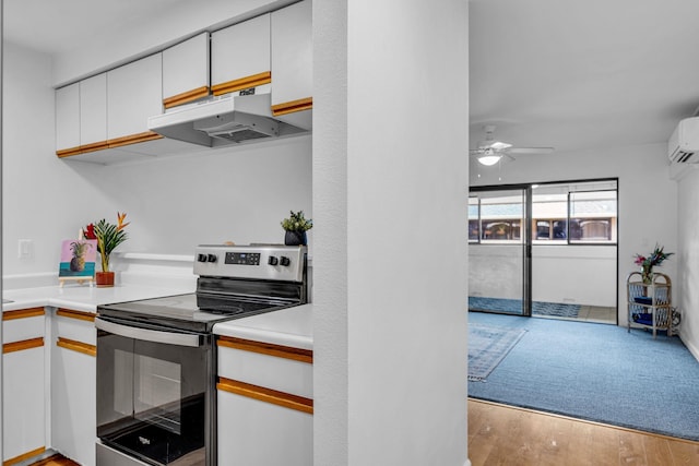 kitchen featuring under cabinet range hood, stainless steel range with electric stovetop, light countertops, and white cabinets