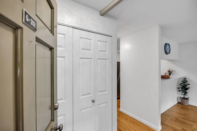 hall with light wood finished floors and baseboards