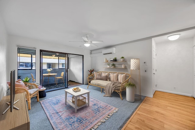living room with baseboards, wood finished floors, a ceiling fan, and a wall mounted AC