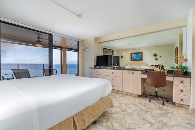 bedroom featuring floor to ceiling windows, a water view, and light tile floors