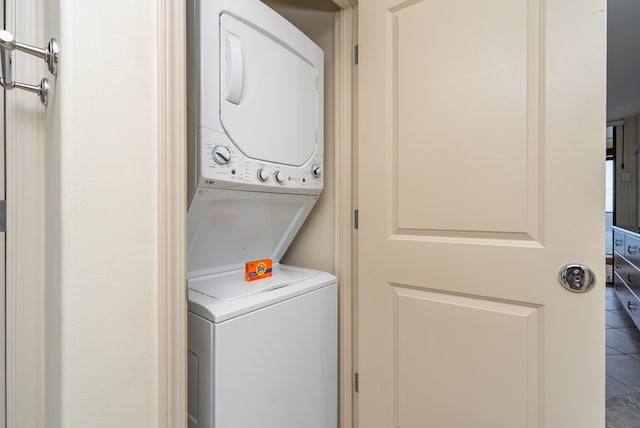 laundry room featuring stacked washer / dryer and tile floors